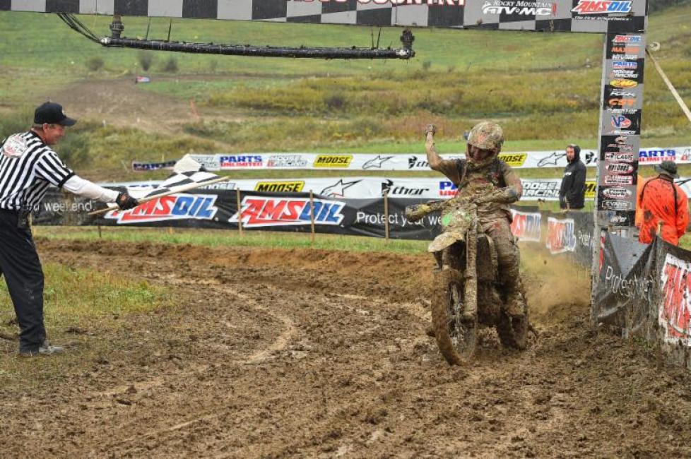 DeLong crosses the muddy finish line after a challenging day of racing.