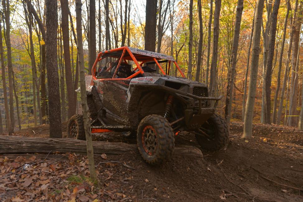 Scott Kiger powers his Polaris over a log in the Ironman woods 
