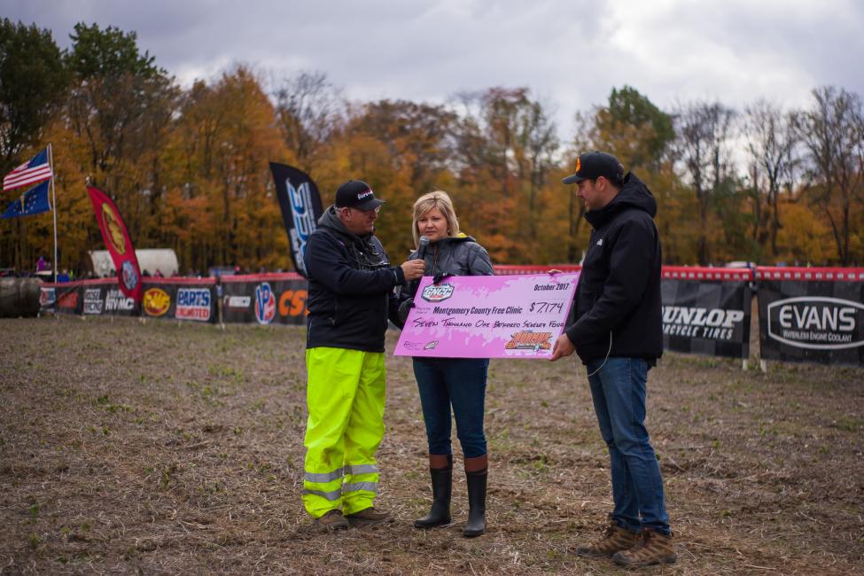 GNCC Event Director, Tim Cotter, presenting Montgomery County Free Clinic's, Kelly Taylor, with a check on the 1 p.m. pro bike start.