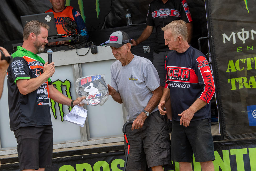 AMSOIL Moto Hero Trevison Brunton (center) with his son, Steve Brunton, being presented the AMSOIL Moto Hero plaque at this weekend's John Penton GNCC. Photo: Shan Moore