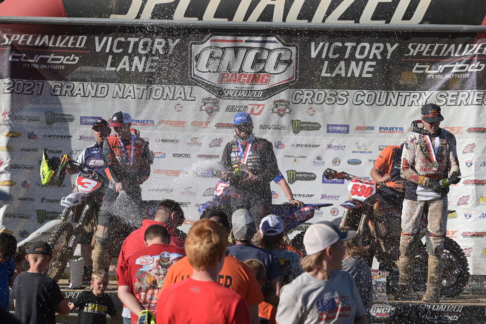 Steward Baylor (center), Ben Kelley (right) and Jordan Ashburn (left) celebrate with champagne showers at round 11. Photo: Ken Hill